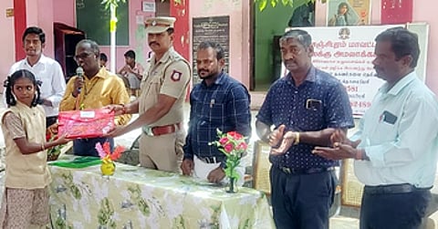 மாணவிக்கு பரிசளித்த மாவட்ட மதுவிலக்கு அமலாக்கப்பிரிவு சாா்பு ஆய்வாளா் ஹரிதாஸ்.