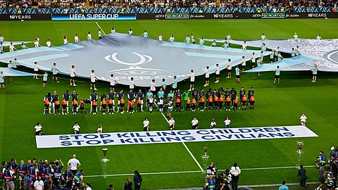 The players line up before the UEFA Super Cup soccer match between Paris Saint-Germain and Tottenham Hotspur in Udine, Italy