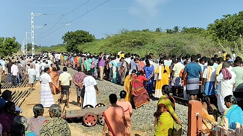 தண்டவாளத்தில் அமர்ந்து போராடும் மீனவர்கள்