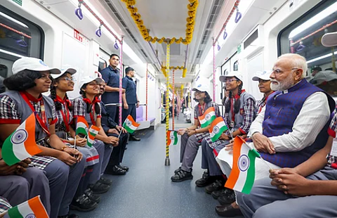கொல்கத்தாவில் வெள்ளிக்கிழமை நடைபெற்ற நிகழ்ச்சியில் 3 புதிய மெட்ரோ வழித்தடங்களை தொடங்கி வைத்த பின்னா் பள்ளி மாணவ, மாணவிகளுடன் மெட்ரோ ரயிலில் பயணித்த பிரதமா் நரேந்திர மோடி.