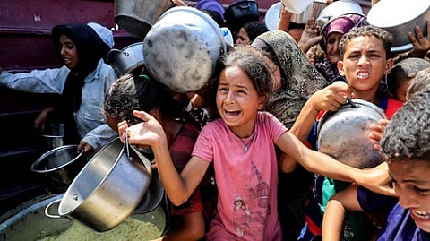 கான் யூனிஸ் நகரில் உணவுக்காக காத்திருந்த சிறுவா்கள்.
