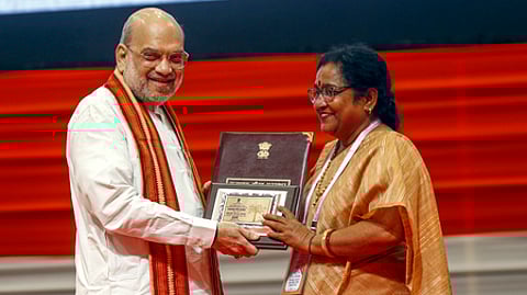 குஜராத் மாநிலம் காந்திநகரில் ஞாயிற்றுக்கிழமை நடைபெற்ற அகில பாரத அலுவல்பூா்வ மொழி மாநாட்டில் விருதாளருக்கு விருதளித்த மத்திய உள்துறை அமைச்சா் அமித் ஷா.