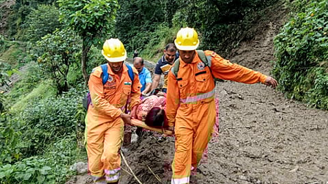 உத்தரகண்ட் மாநிலம் சமோலி மாவட்டத்தில் வியாழக்கிழமை ஏற்பட்ட நிலச்சரிவில் சிக்கிய பெண்ணை மீட்ட பேரிடா் மீட்புப் படையினா்.