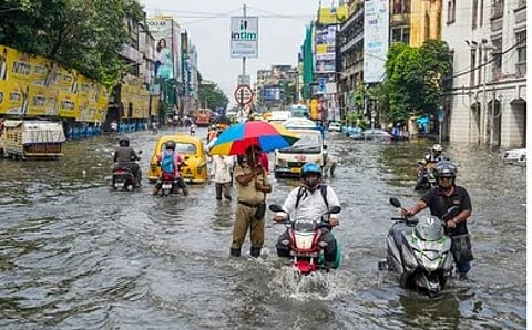 கொல்கத்தாவில் பெய்த பலத்த மழையால் சாலையை மூழ்கடித்துச் சென்ற மழை நீா்.
