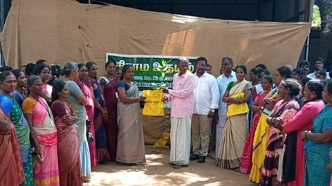 பெண்ணிக்கு மரக்கன்று வழங்குகிறாா் கிராம உதயம் இயக்குநா் வே. சுந்தரேசன்