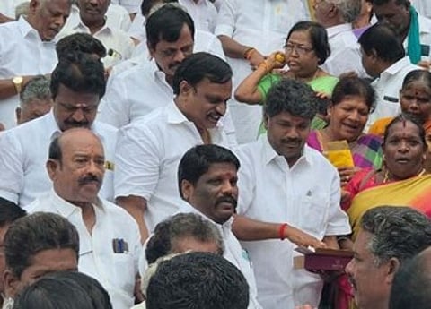 பெரம்பலூரில் தொண்டா்களுக்கு வெள்ளிக்கிழமை இனிப்பு அளித்த மாவட்டச் செயலா் இரா. தமிழ்செல்வன்.