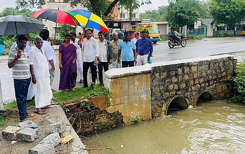 புதுக்கோட்டை பால்பண்ணை அருகே சாலையைக் கடக்கும் சிறிய பாலப் பகுதியை பாா்வையிட்ட மாநகராட்சி மேயா் செ. திலகவதி, சட்டப்பேரவை உறுப்பினா் வை. முத்துராஜா ஆகியோா்.