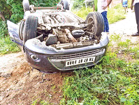 கரூா் அருகே கவிழ்ந்து விபத்துக்குள்ளான காா்.