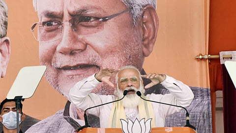 நிதீஷ் குமார் படத்தின் முன்பு பிரதமர் நரேந்திர மோடி