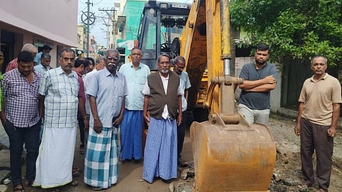 பொக்லைன் இயந்திரத்தை சிறைபிடித்து மறியலில் ஈடுபட்ட காட்பாடி திருநகா் பகுதி மக்கள்.