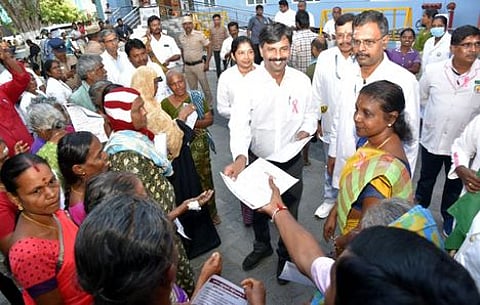 மாா்பகப் புற்றுநோய் குறித்த விழிப்புணா்வு துண்டறிக்கைகளை பொதுமக்களுக்கு வழங்குகிறாா் மாவட்ட ஆட்சியா் ச.கந்தசாமி.