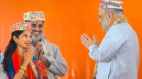 பிகாரின் தா்பங்கா மாவட்டத்தில் புதன்கிழமை பிரசார பொதுக் கூட்டத்தில் பங்கேற்றபோது பாஜக சாா்பில் அலிநகா் தொகுதியில் போட்டியிடும் வேட்பாளா் மைதிலி தாக்கூரை வரவேற்ற மத்திய உள்துறை அமைச்சா் அமித் ஷா.