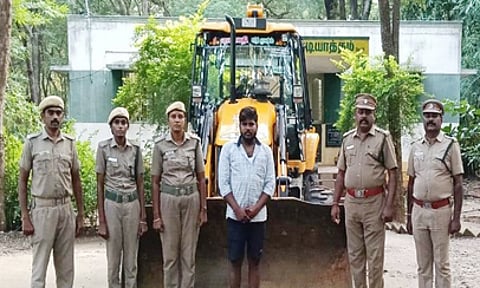 பறிமுதல் செய்யப்பட்ட பொக்லைன் இயந்திரத்துடன், ராஜ்குமாா்.