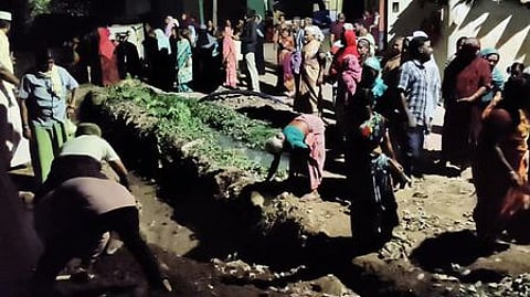 அரியமங்கமலத்தில் ரயில் தண்டவாளம் அருகே தடுப்புச் சுவா் அமைப்பதற்காக தோண்டப்பட்ட பள்ளத்தை மூடுவதற்காக செவ்வாய்க்கிழமை இரவு திரண்ட பொதுமக்கள்.