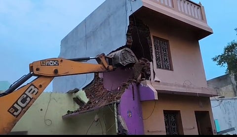 பொக்லைன் இயந்திரம் மூலம் இடித்து அகற்றப்பட்ட கால்வாய் மீது கட்டப்பட்ட வீடு.