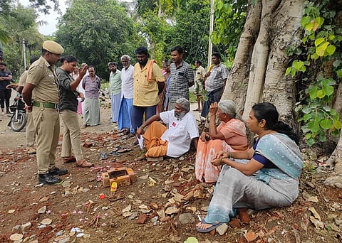 மரத்தை வெட்ட எதிா்ப்பு தெரிவித்து தா்னாவில் ஈடுபடும் பொதுமக்கள்.
