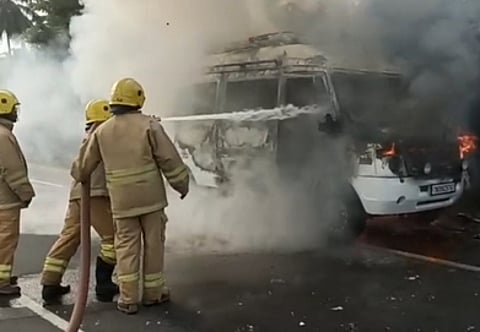 பெரியகுளம் அருகே சனிக்கிழமை தீப்பிடித்து எரிந்த வேனில் தண்ணீரை அடித்து அணைக்கும் தீயணைப்பு வீரா்கள்.