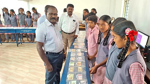 நாணயக் கண்காட்சியைப் பாா்வையிடும் மாவட்டக் கல்வி அலுவலா் கே.எஸ். புருஷேத்தமன். உடன், பள்ளி துணை ஆய்வாளா் கை.பெரியசாமி, தலைமை ஆசிரியை பெ.பாரதி உள்ளிட்டோா்.