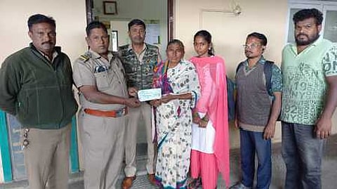 உயிரிழந்தவரின் குடும்பத்துக்கு நிவாரணத் தொகைக்கான காசோலையை வழங்குகிறாா் உதகை வனச் சரகா் செல்வகுமாா்.