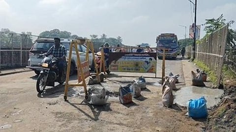 சாலையில் ஏற்பட்டுள்ள பள்ளத்தை அடையாளப்படுத்த வைக்கப்பட்டுள்ள தடுப்புகள்.