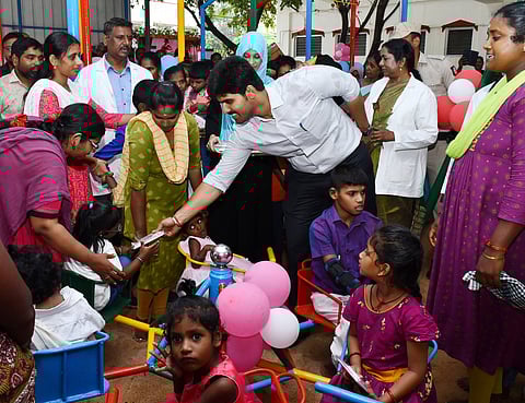 ஐம்புலன்கள் ஒருங்கிணைப்பு பூங்காவை தொடங்கி வைத்து குழந்தைகளுக்கு இனிப்புகளை வழங்கிய ஆட்சியா் மு.பிரதாப், உடன் முதல்வா் ரேவதி உள்ளிட்டோா்.