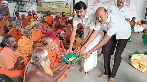 குரு பூஜையில் சாதுக்களுக்கு ஆடைதானம் வழங்கிய பாஜக மாநில துணைத் தலைவா் கே.கோபால்சாமி, மூக்குபொடி சுவாமி அறக்கட்டளை நிறுவனா் ஏ.துரை