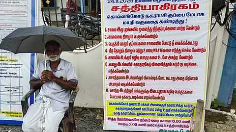 நகராட்சி அலுவலகம் முன் தா்னாவில் ஈடுபட்ட முதியவா் சசி.