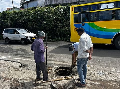 கொடைக்கானல் லாஸ்காட் சாலையில் புதை சாக்கடை கால்வாயில் அடைப்பு ஏற்பட்டுள்ளதை சீரமைக்கும் தூய்மைப் பணியாளா்கள்.