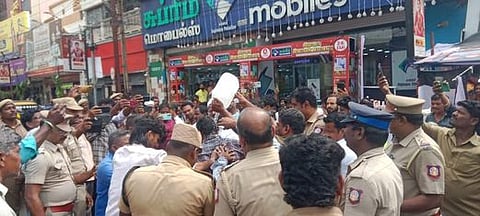 திருச்சி என்எஸ்பி சாலையில் புதன்கிழமை தீக்குளிக்க முயன்ற தரைக்கடை வியாபாரி.