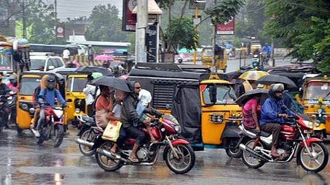மதுரை பெரியாா் பேருந்து நிலையம் பகுதியில் சனிக்கிழமை பெய்த மழையினூடே பயணித்தவா்கள்.