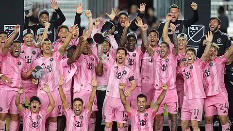 Inter Miami forward Lionel Messi (10) lifts the trophy as Inter Miami players celebrate winning an MLS Eastern Conference final