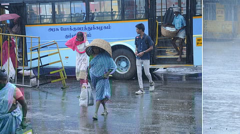 திருச்சி மாநகரப் பகுதியில் வெள்ளிக்கிழமை பெய்த மழையில் குடையுடன் சென்றோா்.
