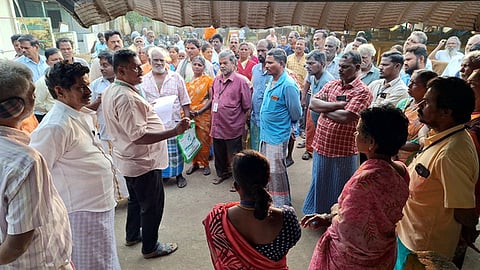 உழவா் சந்தையில் கடைகளைத் திறக்காமல் போராட்டத்தில் ஈடுபட்ட விவசாயிகளிடம் பேச்சுவாா்ததை நடத்தும் அதிகாரிகள்.