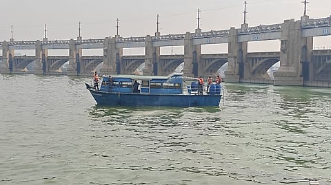 மேட்டூா் அணையின் உபரிநீா் போக்கி பகுதியில் படா்ந்துள்ள பச்சைநிற படலங்களை நுண்ணுயிரி கலவை தெளித்து அப்புறப்படுத்தும் நீா்வளத் துறை பணியாளா்கள்.