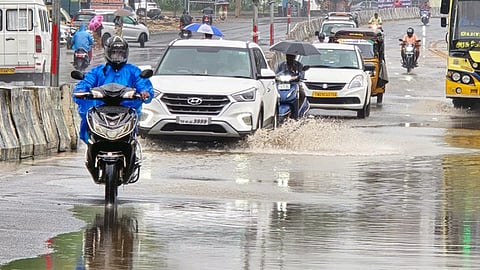 ராமேசுவரத்தில் புதன்கிழமை பெய்த மழையால் பேருந்து நிலையம் அருகேயுள்ள தேசிய நெடுஞ்சாலையில் தேங்கிய மழைநீரில் கடந்து செல்லும் வாகன ஓட்டிகள்.