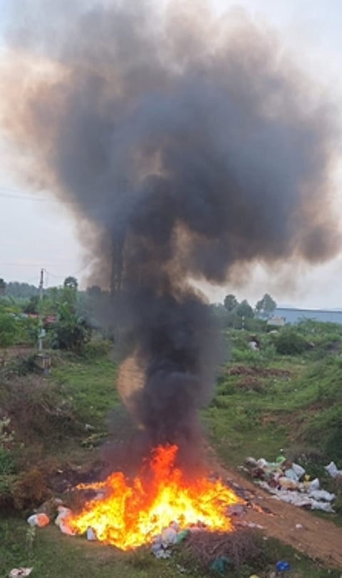 ஒட்டன்சத்திரம் பிரதான சாலையோரத்தில் கொட்டப்பட்ட கழிவுகளுக்கு தீ வைக்கப்பட்டதால் ஏற்பட்ட கரும்புகை.