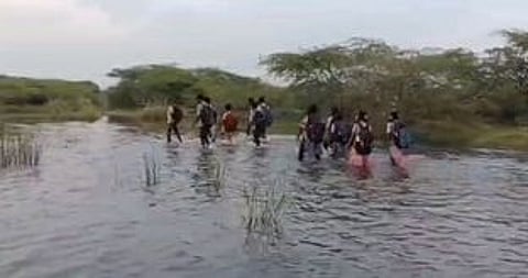 இடுப்பளவு தண்ணீரைக் கடந்து
மாணவா்கள் பள்ளி செல்லும் அவலம்