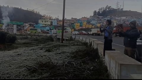 உதகையை அடுத்த தலைகுந்தா பகுதியில் புற்கள் மீது படா்ந்திருந்த பனியை புகைப்படம் எடுத்த சுற்றுலாப் பயணிகள்.