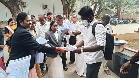 நீதிமன்ற வளாகத்தில் பொதுமக்களுக்கு துண்டுப் பிரசுரங்களை வழங்கிய நீதிபதிகள், வழக்குரைஞா்கள்.