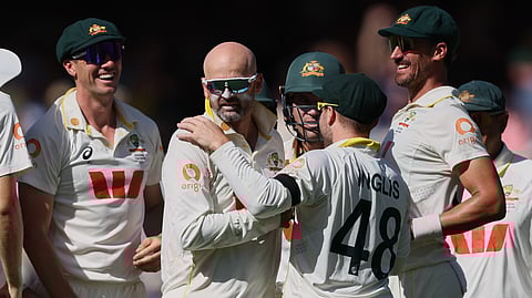 Australia's Nathan Lyon, second left, is congratulated by teammates after dismissing England's Ben Stokes during play on day four of the third Ashes cricket England Australia Adelaide