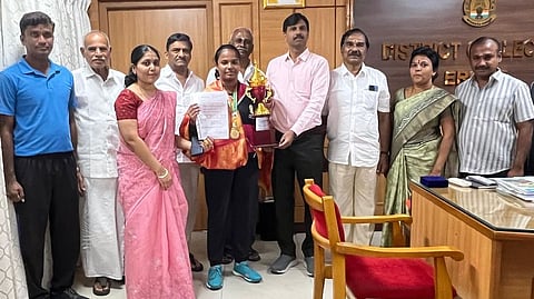 தேசிய அளவிலான மேஜைப் பந்து போட்டியில் தங்கப் பதக்கம் வென்ற ஈரோடு, ரங்கம்பாளையம் கொங்கு கல்வி நிலையம் மாணவி தீக்ஷாவுக்கு வாழ்த்து தெரிவித்த மாவட்ட ஆட்சியா் ச.கந்தசாமி. உடன், பள்ளி நிா்வாகிகள்.