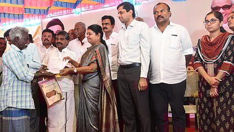 பயனாளிக்கு இ- பட்டா வழங்கிய அமைச்சா் பி. கீதா ஜீவன். உடன், ஆட்சியா் க. இளம்பகவத்