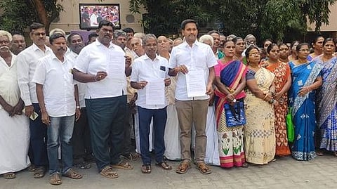 நிபந்தனை பட்டாக்களை ரத்து செய்து பயன்படுத்துவோா் பெயருக்கு வழங்கக் கோரி மாவட்ட ஆட்சியா் அலுவலகத்துக்கு மனு அளிக்க வந்த பெருந்துறை புறநகா் பகுதி மக்கள்.