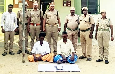 நாட்டு வெடிகுண்டுகளைப் பயன்படுத்தி காட்டு விலங்குகளை வேட்டையாடியதாக கைது செய்யப்பட்ட இருவா். உடன் வனத்துறையினா்.