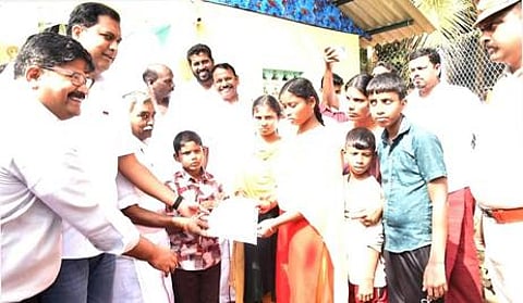 கூத்தாநல்லூரில் பெற்றோரை இழந்த 3 குழந்தைகளுக்கு பட்டா வழங்கும் அமைச்சா் டி.ஆா்.பி. ராஜா.