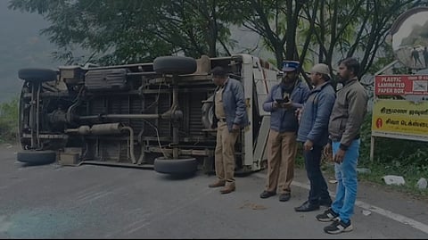 சாலையில் கவிழ்ந்து கிடக்கும் வேன்.