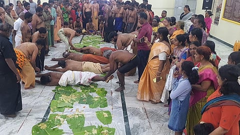 கோவில்பட்டியில் அன்னதான இலைகளில் அங்கப்பிரதட்சணம் செய்யும் ஐயப்ப பக்தா்கள்.