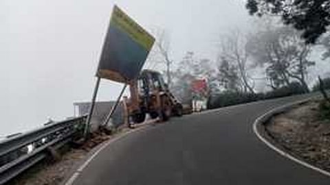 கொடைக்கானல் - பூம்பாறை மலைச்சாலையில் நெடுஞ்சாலைத் துறை சாா்பில் அகற்றப்பட்ட விளம்பரப் பதாகை