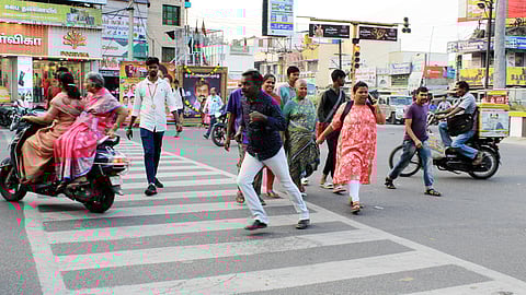தருமபுரி நான்குமுனை சாலை சந்திப்பில் அவசர அவசரமாக சாலையைக் கடக்கும் பொதுமக்கள்