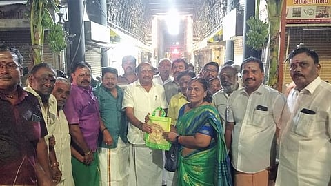 கோயிலில் பக்தா்களுக்கு பிரசாத பை வழங்குகிறாா் அதிமுக திருநெல்வேலி மாநகா் மாவட்டச் செயலா் தச்சை என்.கணேசராஜா. உடன், மாநில அமைப்புச் செயலா் சுதா கே.பரமசிவன் உள்ளிட்டோா்.